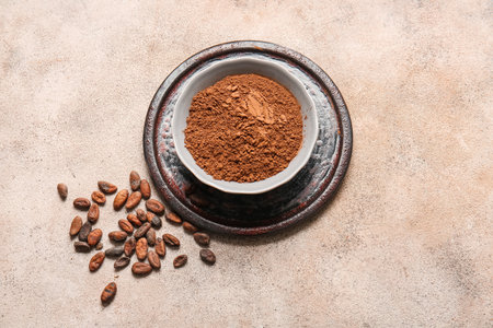 Bowl with cocoa powder and beans on light backgroundの写真素材