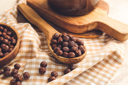 Spoon with chocolate corn balls on table
