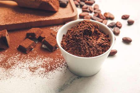 Bowl with cocoa powder on light backgroundの写真素材