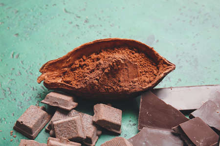 Cocoa powder and chocolate on color backgroundの写真素材