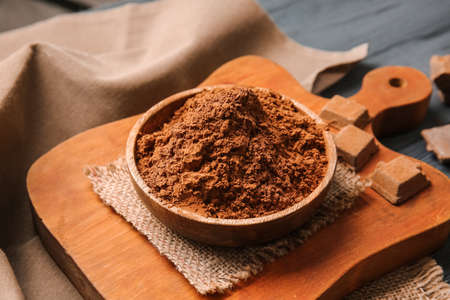 Bowl with cocoa powder on dark wooden backgroundの写真素材
