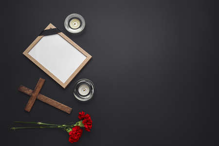 Composition with photo frame and wooden cross on dark backgroundの写真素材