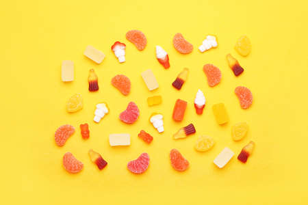 Different jelly candies on color background