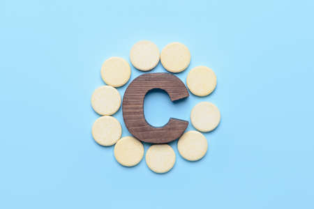 Letter C and vitamin pills on color backgroundの写真素材