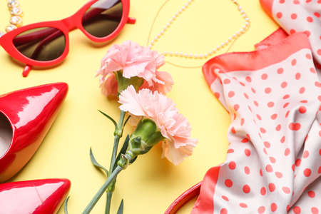 Composition with beautiful flowers, sunglasses and shoes on color backgroundの写真素材