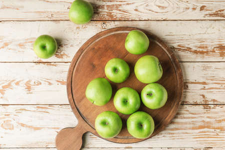 Board with fresh green apples on tableの写真素材