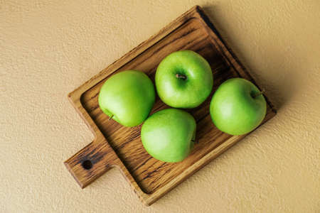 Board with fresh green apples on color backgroundの写真素材