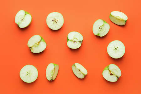 Pieces of fresh apples on color backgroundの写真素材