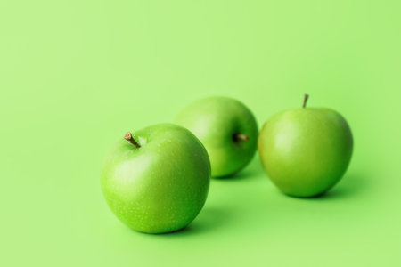 Fresh green apples on color backgroundの写真素材