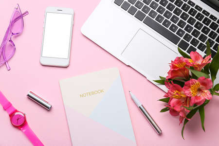 Composition with laptop, flowers, notebook and accessories on color backgroundの写真素材