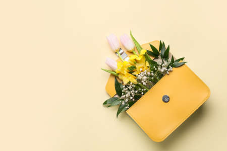 Bag with beautiful flowers on color background