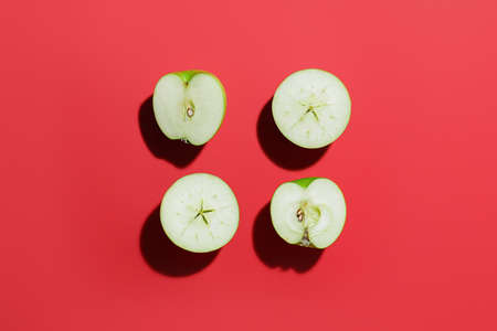 Pieces of fresh apples on color backgroundの写真素材