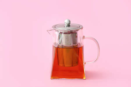 Teapot with hot tea on color backgroundの写真素材