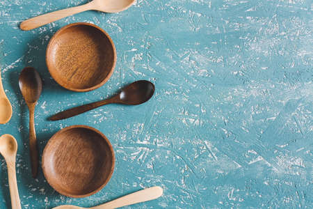 Wooden spoons and bowls on color backgroundの写真素材