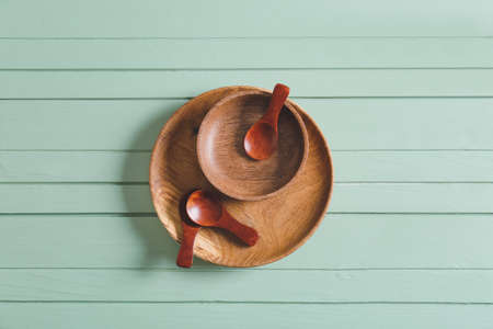Spoons and bowls on color wooden backgroundの写真素材
