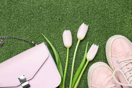 Beautiful tulips, stylish bag and shoes on color backgroundの写真素材
