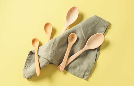 Wooden spoons and napkin on color backgroundの写真素材