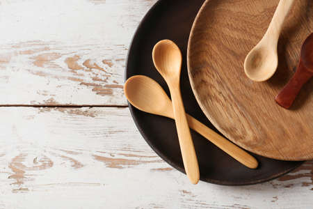 Spoons and plates on light wooden backgroundの写真素材