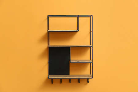 Modern empty shelf hanging on color wallの写真素材