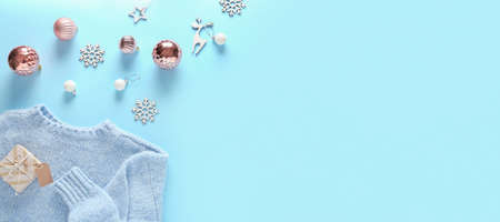 Beautiful Christmas decorations with sweater and gift on blue background with space for textの写真素材