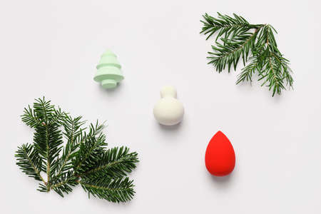 Christmas tree branches with makeup sponges on white backgroundの写真素材