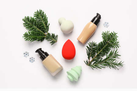 Christmas composition with makeup sponges and tonal foundation on white backgroundの写真素材