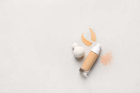 Makeup sponge with tonal foundation and powder on gray backgroundの写真素材