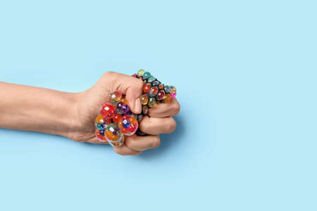 Female hand squeezing stress ball on color backgroundの写真素材