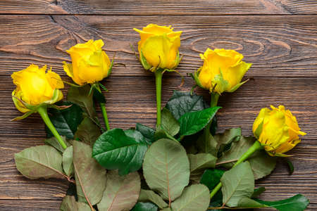 Beautiful yellow roses on wooden backgroundの写真素材