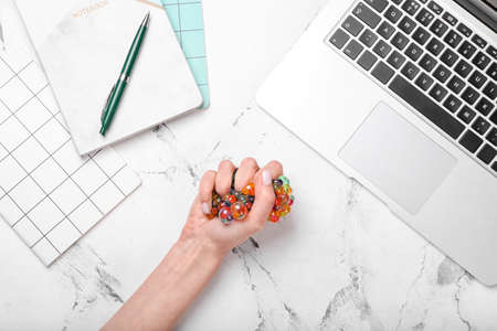 Female hand squeezing stress ball on light backgroundの写真素材