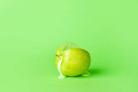 Green apple with white paint on color backgroundの写真素材