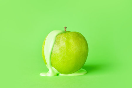 Green apple with white paint on color backgroundの写真素材