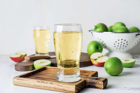 Board with glass of apple cider on tableの写真素材