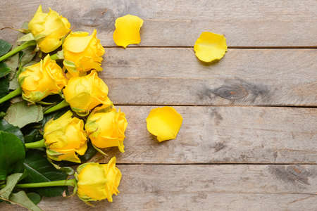 Beautiful yellow roses on wooden backgroundの写真素材