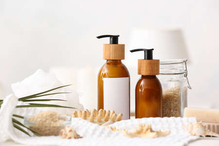 Spa set with bottles of cosmetics on light backgroundの写真素材