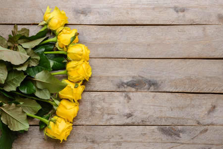 Beautiful yellow roses on wooden backgroundの写真素材