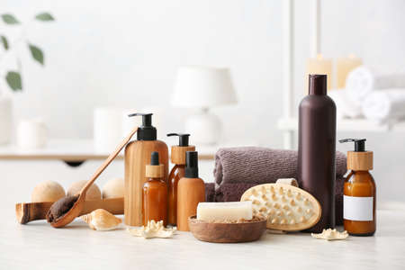 Spa set with bottles of cosmetics on light background