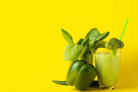 Glass of healthy green smoothie and ingredients on color backgroundの写真素材
