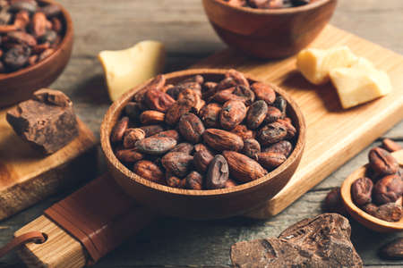 Bowl with cocoa beans on wooden backgroundの写真素材