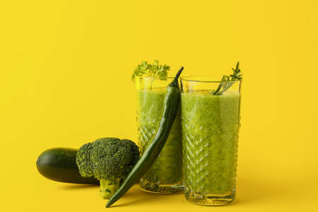 Glasses of healthy green smoothie and ingredients on color backgroundの写真素材