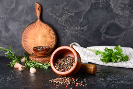 Mortar and pestle with peppercorns on dark backgroundの写真素材