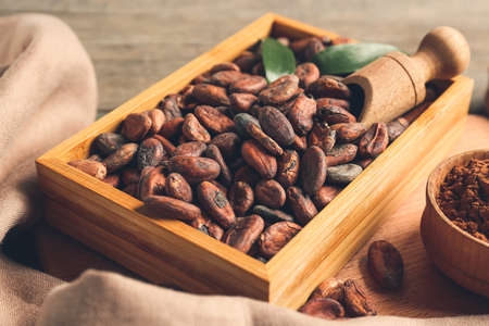 Box with cocoa beans on wooden backgroundの写真素材