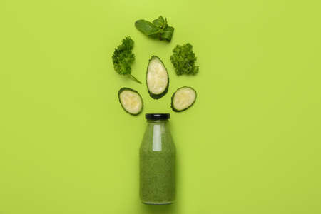 Composition with bottle of healthy green smoothie and ingredients on color backgroundの写真素材