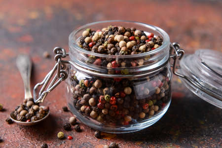 Jar and spoon with peppercorns on grunge backgroundの写真素材