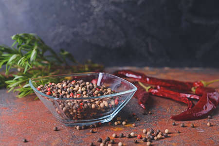 Bowl with peppercorns on grunge background