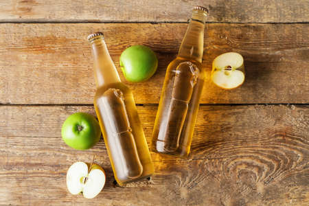 Bottles of apple cider on wooden tableの写真素材