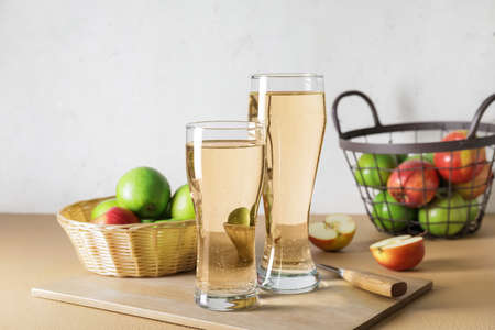 Glasses with apple cider and baskets on tableの写真素材