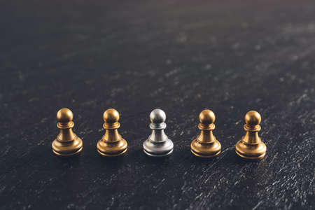 Silver and golden pawns on dark backgroundの写真素材