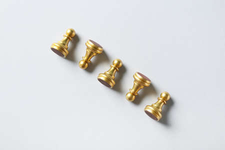Golden pawns on white backgroundの写真素材