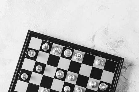 Chess board with pieces on light background